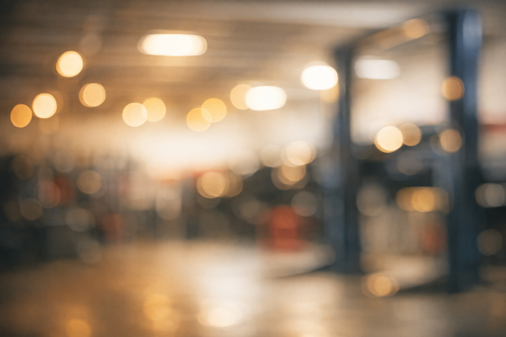 [dark] Rolig baggrund til anmeldelser: defokuseret værkstedslys og bokeh fra lamper/værktøj—skal ikke stjæle fokus fra tekst.